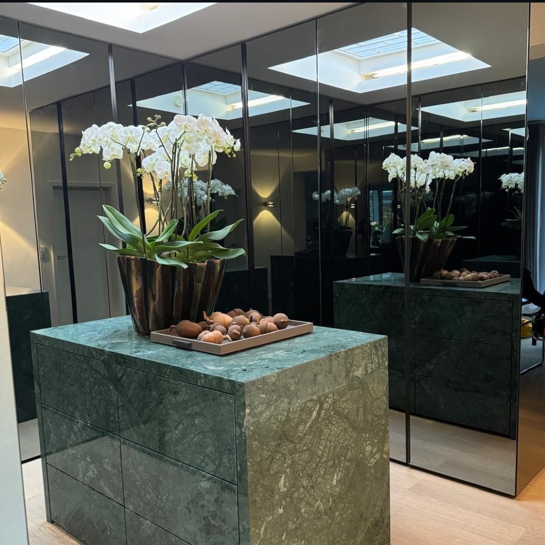 Ankleidenblock aus Naturstein vor Schrankfronten aus Rauchglasspiegel